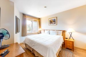 马姆莫斯湖Juniper Springs 444的一间卧室配有一张床、一张书桌和一个窗户。