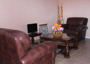 LaborieBelle View Apartment Villa- Lilac的客厅配有沙发和鲜花桌
