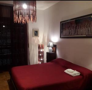 福贾Casa Trastevere的一间卧室配有一张红色的床和吊灯。