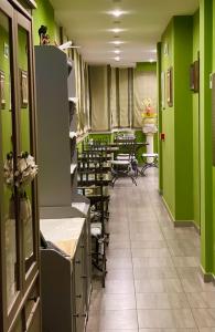 菲乌米奇诺瑞莱别墅酒店的一间拥有绿色墙壁和桌椅的美发沙龙