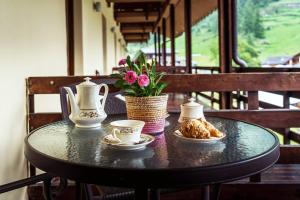 格雷索拉特里尼泰Chalet du Lys Hotel & SPA的一张带茶杯和鲜花的黑桌