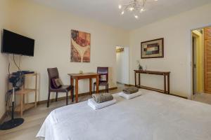 阿布里斯Estrella del Mar的一间卧室配有一张带两把椅子的床和一台电视。