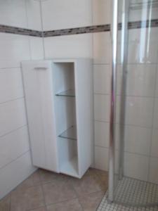 诺特海姆Ferienwohnung Jürges的带淋浴的浴室内的白色橱柜