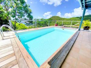 KoolbaaiAquamarine, private room in Villa Casa Blue pool sea view的一座位于庭院中的游泳池,庭院内有山地背景