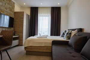 科帕奥尼克L&N Apartmani Kopaonik-Milmari Resort的酒店客房,配有床和沙发