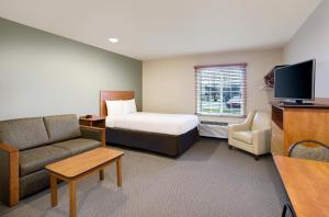 马纳萨斯WoodSpring Suites Manassas Battlefield Park I-66的酒店客房,配有床和沙发