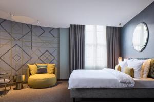 伍珀塔尔Postboutique Hotel Wuppertal的一间卧室配有一张大床和一张黄色椅子