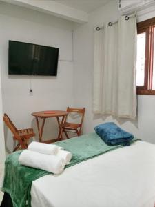 格拉玛多Espaço da Mélia的配有床、桌子和电视的房间