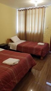 卡瓦纳科德Las Palmeras Eco Hostel的酒店客房,配有两张带红色床单的床