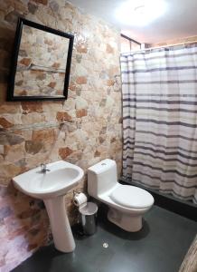 卡瓦纳科德Las Palmeras Eco Hostel的浴室配有白色卫生间和盥洗盆。