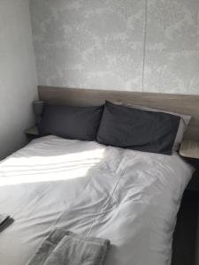 伊尔弗勒科姆Peaceful Paradise的一张未铺床,上面有两个枕头