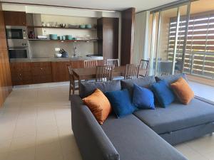 吉亚Herdade dos Salgados - Apartamento T2的一间带蓝色沙发的客厅和一间厨房