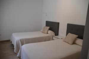 Las PuntasCASA MAR AZUL的白色墙壁客房的两张床