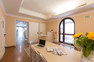 朱利亚诺瓦Ristorante Hotel Lucia - 100 mt dal mare的用餐室配有带笔记本电脑的桌子