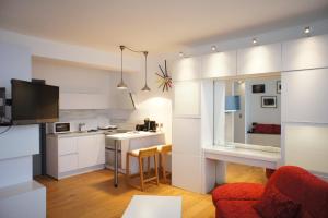 布鲁塞尔博莱蒙特OHY公寓的厨房以及带白色橱柜和红色沙发的客厅。