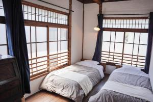 竹田竹田站前青年旅舍的带大窗户的客房内的两张床