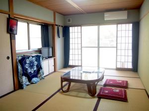SaikaiYukinoura Guest House Moritaya的客厅配有玻璃桌和沙发