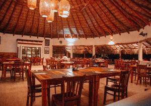 蒙特里科Dos Mundos Pacific Resort的餐厅设有一张大型木桌和椅子
