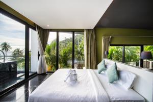 芭东海滩See Sea Villa Phuket SHA的一间卧室设有一张大床和大窗户
