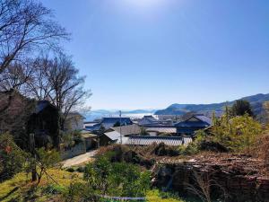 Ichii島旅農園ほとり お手紙と農の宿的山丘上一组房子,背景是山丘