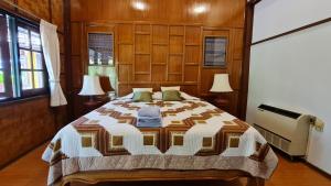 湄宏颂Hotel Siblanburi Resort的一间卧室配有一张床和两盏灯及窗户。