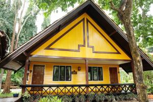 湄宏颂Hotel Siblanburi Resort的一间黄色的小房子,有黑色的屋顶