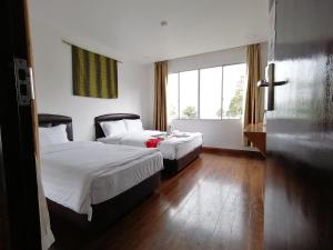 昆达桑Ayana Holiday Resort的酒店客房设有两张床和窗户。