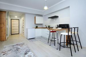 阿拉木图New and cozy studio in the best area! 4的厨房配有白色橱柜、桌子和凳子