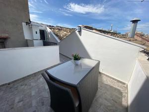 巴勒莫La Piccola Formica Charme Rooms的屋顶上设有白色阳台,配有桌椅