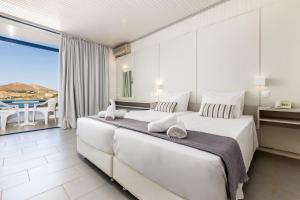 纳乌萨海马酒店的白色卧室设有一张大床和一个阳台