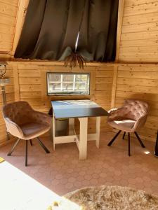 埃尔瑟尔Luxe Finse Kota met Jacuzzi en SaunaBarrel de Zandhoef的一间带桌子和两把椅子的用餐室