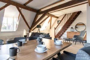 奎德林堡Ferienwohnungen im Weingarten Quedlinburg的客厅配有木桌和椅子