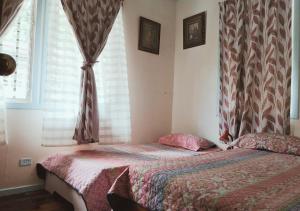 戈尔菲托Golfito Maison D'hôtes的卧室在窗户前配有一张床