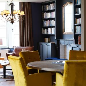罗什福尔Les Terrasses des Falizes B&B的一间带桌子和黄色椅子的用餐室