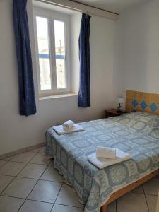 圣马迪拉莫Le Cocardier的一间卧室设有一张床和一个窗口