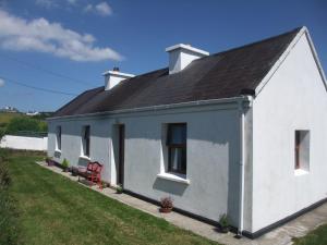 Achill SoundKatie's Cottage的黑色屋顶的白色房子