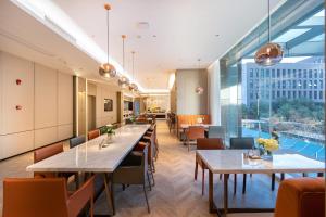 武汉武汉金银湖亚朵酒店的餐厅设有桌椅和大窗户。