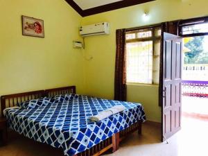 卡乌罗西姆Lobo's Guesthouse的一间卧室配有一张蓝色和白色的床