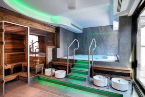 奥斯纳布吕克Holiday Inn - Osnabrück, an IHG Hotel的浴室配有4个盥洗盆和浴缸。