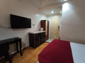 克提DARUL SALAM INN HOTEL的客房设有1张床、1张办公桌和1台平面电视。