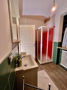 福萨诺La Casa delle Favole的一间带水槽和红色冰箱的浴室
