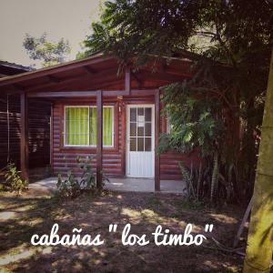 伊图萨因戈Cabañas Los Timbó的一间红色的小房子,有白色的门