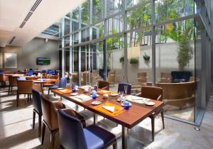 巴拿马城巴拿马环球酒店的餐厅设有木桌、椅子和窗户。