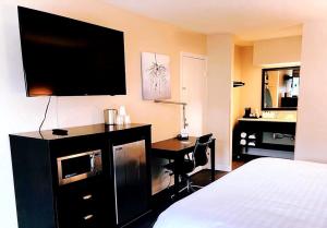 佛罗伦萨Clarion Inn & Suites的酒店客房配有一张床和一张书桌及一台电视