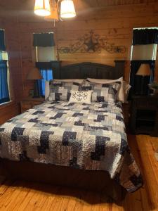 Lakewood HarborLake Whitney Log Cabin的一间卧室配有一张带黑白棉被的床