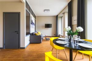 圣彼得堡Grani Aparthotel的一间带桌子和黄色椅子的用餐室