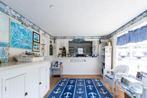 West Harwich海滩微风汽车旅馆的厨房拥有蓝色和白色的墙壁,铺有蓝色地毯。