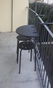 伊夫雷亚...per il Sirio的一张黑桌和椅子坐在栏杆旁