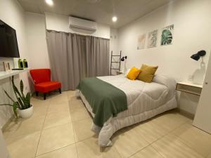 贝伦埃斯科巴Studio Estrada 2 Escobar的一间卧室配有一张床和一张红色椅子