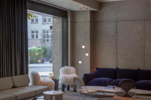 斯图加特EmiLu Design Hotel的带沙发和椅子的客厅以及窗户。